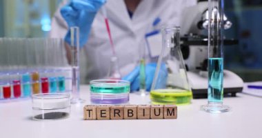 Kendini adamış bir bilim adamı laboratuvar ortamında Terbiyum olarak adlandırılan kimyasallarla çeşitli karmaşık deneyler yapıyor.