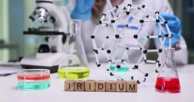 Bilim araştırmaları için deney tüpleri, mikroskop ve moleküler modelli iridyum sergiliyor..