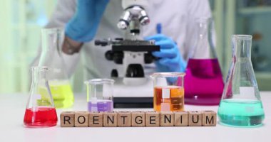 Bir laboratuvar sahnesi mikroskop ile çeşitli renklerde kimyasal çözümler sunuyor.