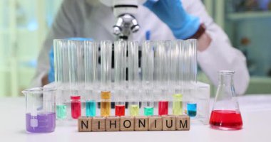 Kendini adamış bir bilim adamı modern, gelişmiş bir laboratuvarda Nihonium 'un karmaşık kimyasal reaksiyonlarını inceliyor.