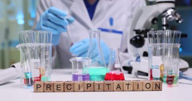 Renkli çözümler ve eğitim amaçlı araçlarla yağış kimyasını gösteren bir laboratuvar kurulumu