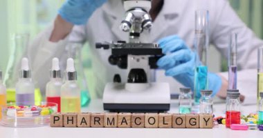 Detaylı araştırma ve analiz için mikroskop ve renkli kimyasallarla laboratuarda farmakoloji araştırması yapmak.