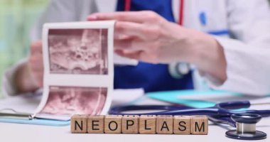 Bir sağlık uzmanı temel tıbbi görüntüleri analiz eder ve inceler, özellikle neoplazmalar üzerinde yoğunlaşır.