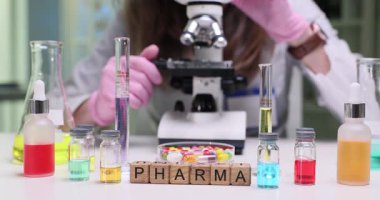 Yetenekli bir eczacı, canlı bir laboratuvar ortamında mikroskop altında çeşitli örnekleri dikkatlice inceler.