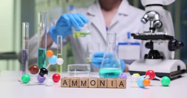 Bir laboratuvar ortamında, bir bilim adamı çeşitli cam ve modeller kullanarak amonyak deneyleri gerçekleştirir.