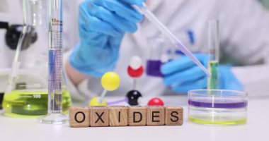 Canlı bir laboratuvar sahnesi çeşitli oksitlerin kimyasal deneylerle olan karmaşık etkileşimini gözler önüne seriyor.