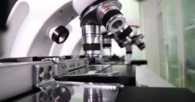Tıbbi araştırma laboratuvarında farklı merceklere ve slaytlara sahip modern güçlü mikroskoplar. Tıp laboratuarında ekipman üzerinde çalışan numuneler