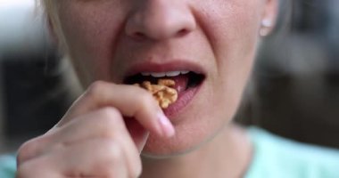 Genç kadın cevizi ağzına alır ve ısırarak koparır yavaşça çiğnemeye başlar nazikçe gülümseyerek. Hanımefendinin tattığı an samimi bir his yaratır.