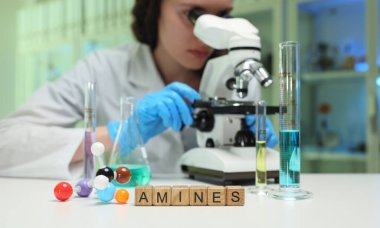 Bir bilim adamı bir laboratuvar araştırma ortamında aminleri incelemek için bir mikroskop kullanıyor.