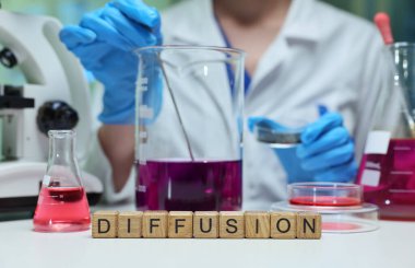 Bir bilim adamı, canlı çözümler ve ekipmanlarla dolu bir laboratuvarda büyüleyici bir dağılım süreci sergiliyor.