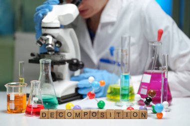 Bir bilim adamı mikroskop altında rengarenk bir laboratuvarda çürüme araştırmasına odaklanmış örnekleri inceliyor..