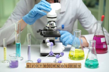 Titiz bir bilim adamı gelişmekte olan bir biyoteknoloji laboratuvarında gelişmiş bir mikroskop altında çeşitli örnekleri dikkatle inceliyor.