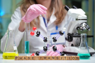 Deneyimli bir uzman gelişmiş mikroskoplar ve renkli sıvılar kullanarak karmaşık bir faz geçiş deneyi gerçekleştirir.