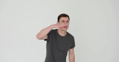 Koyu gri tişörtlü, elleri alnından alnına kadar kalkık, mesafeye bakmak için gözleri gölgeleyen bir adam. Hareket arama önerir ve daha net görünüm almaya çalışır