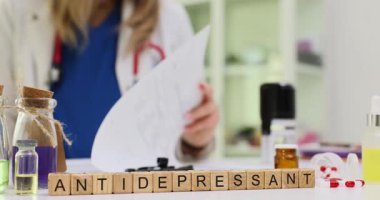 Tahta bloklar doktor masasındaki ilaç şişeleri arasında antidepresan kelimesini heceler. Psikiyatrist, hasta ruhsal sağlığı desteği için reçete planını gözden geçirdi