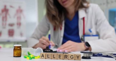 Sözcüklere alerjisi olan tahta küpler ilaç aletleri ve renkli haplar arasındadır. Genel tedavi yöntemlerini işaret eden parlak kapsüller çevresel terim