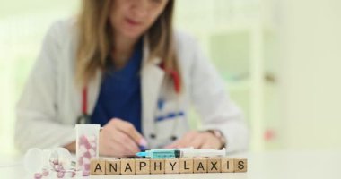 Tahta küplerde şırınganın yanında anafilaksi ve ampuller görülüyor. Tıbbi araçlar alerjilere ve acil tedaviye acil durum tepkisini vurguluyor