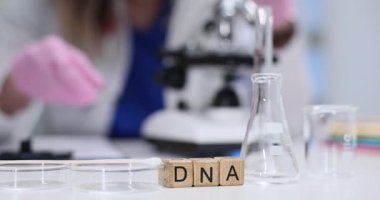 Cam mataralar ve mikroskop ile yerleştirilen tahta küplerden yapılmış DNA. Laboratuvar ekipmanları terimi bilimsel laboratuardaki genetik ve hücresel araştırmalara bağlar