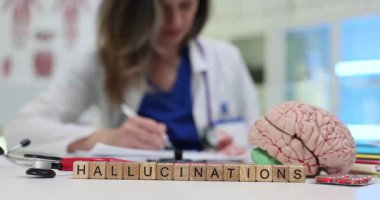 Tahta bloklardaki halüsinasyonlar ve doktor işyerindeki insan beyni modelleri. Psikiyatrist, akıl sağlığı bozukluğunun teşhisini hastanede yazıyor.