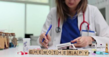 Doktorun ultrason belgelerini incelerken masasında kemoterapi olan tahta bloklar. Klinikteki kanser ve terapilerle ilgili tıbbi tedavilere odaklanın