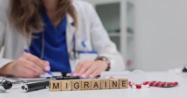 Migren 'in olduğu tahta bloklar tıbbi profesyonel yazı kayıtlarının yanında. Klinikteki nörolojik durumun teşhisi ve tedavisine odaklanın