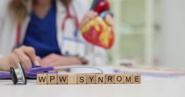 Tahta küpler masada WPW Sendromu 'nu hecelerler ve laboratuvarda nadir görülen bir hastalık teması yaratır. Doktor kalp ritmi bozukluğunu kalp modelinin yanında çözen notları inceliyor.