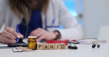 Panik kelimesi steteskop ve şişenin yanındaki beyaz masada zihinsel bir sorun gösteriyor. Tıbbi çalışma alanı atmosfer vurgulama önemi yaratır