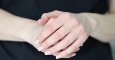 Kadın nazikçe elini okşar ve düzgün tırnaklarını ve yüzüğünü gösterir. Kişisel bakım kavramları ve durgunluk ve rahatlama anı.