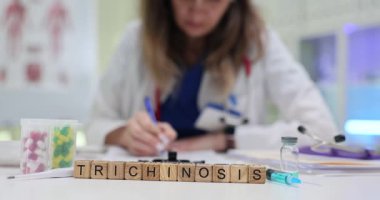 Tahta bloklarda trişinoz ve masada kadın tıbbi uzmanların yazdığı haplar. Parazitoloji teşhisi ve parazit hastalıklarının tedavisi