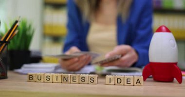 Masadaki tahta bloklarda kadınların para saymasına karşı bir iş fikri. Ofis masasında yeni iş girişimi için mali planlama ve yatırım