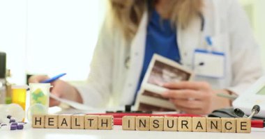 Ahşap bloklar üzerine Heath Sigorta ve tıbbi ceket giyen kadın kayıt tutuyorlar. Sağlık hizmetlerinin idari ve mali yönleri