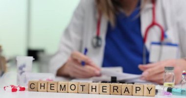 Kadın doktor, kemoterapi yakınında masa başındaki tahta bloklarda evrakları imzalıyor. Kanser ve farmasötik ve idari yönlerin tıbbi tedavisi