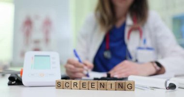 Masadaki bloklarda kan basıncı monitörü ve doktor yazısıyla görüntüleme. Hastalıkların tespiti için sağlık tedbirleri