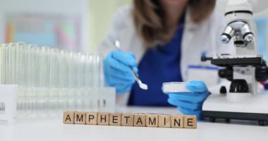 Söz amfetamin, parlak steril laboratuvardaki tahta küplerde göze çarpar. Uyuşturucu maddesi kaşıkla ve kimyasal test analizi öneren yemeklerle ilgilidir.