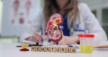 Küpler, böbrek modelinin yanına yerleştirilmiş hematüri ve idrar örneği oluşturur ve tıbbi bağlam yaratır. Parlak laboratuvar ışığı çerçeveye girer klinik berraklık yaratır