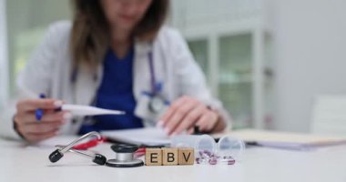 Tahta küplerde steteskop yakınında EBV ve viral doğayı gösteren haplar var. Ofiste ışık, teşhis masasının etrafında temiz atmosfer yaratıyor.