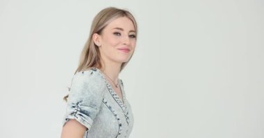 Uzun dalgalı saçlı bir kadın yavaşça misafirlere doğru yürür. Kot elbiseli sarışın kadın davetkar bir şekilde elle hareket ediyor. Yavaş çekim