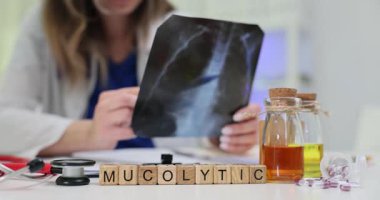 Tahta küplere göre röntgen ve bitkisel şişenin yanında Mucolytic kelime var. Sözcük, kapsüller ve bal özüyle desteklenen solunum rahatlamasına bağlanır