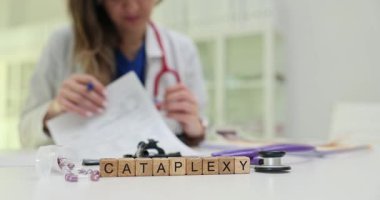 Tahta küplerde ilaç yanında Cataplexy ve doktor tarafından steteskop kullanılıyor. Terim, gözle görülür tedavi işaretlerine bağlı ani kas zayıflığını tanımlar