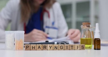 Farenjit, doktor steril masasına yerleştirilmiş özel bloklarda göze çarpıyor. Kadın sıhhiyeci, gırtlak enfeksiyonunu inceleyen sıvı karışımının yakınında çalışıyor.