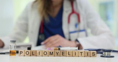 Küplerle yaratılan polimiyelit kelimesi şırınga ve ampulün yanında duruyor. Kadın doktor viral hastalık uyarısıyla ilgili mektup tutuyor.