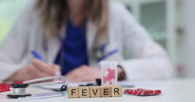 Tahta küplerdeki ateş kelimesi termometre ve kırmızı su toplamalı doktorlara karşı. Araçlar hastalık sırasında sıcaklık kontrolü ve ilaç verilmesini öneriyor