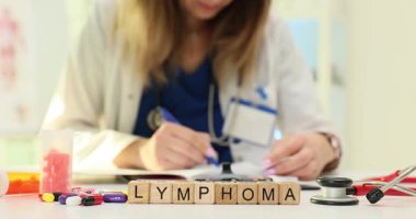 Tahta bloklar hakkındaki lenfoma kelimesi renkli haplar ve tıbbi formların karışımının yanına konmuş. Söylentilere göre kan kanseri için kesin ilaç gerekiyormuş.