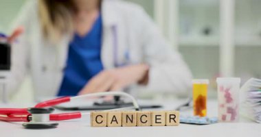 Tahta bloklar kanserli kelimenin steteskop ve şişeye yakın durduğunu söyler. Doktor araştırma ve planlama süreci için çalışıyor.