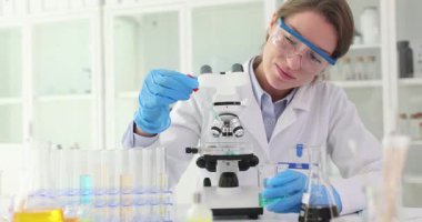 Laboratuvar çalışanı Petri kabına sıvı atmak için pipet kullanıyor. Teknisyen mikroskobik gözlem için pipette sıvı damlaları kullanır.