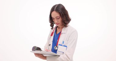 Doktor, beyaz duvardaki hasta için detaylı talimatlar içeren reçete formunu dikkatlice dolduruyor. Doktor klinikteki belgeye pul yapıştırdı