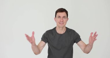 Duygusal adam öfkesini ifade eder. Beyaz arka planda yürürken kollarını kaldırır. Gri tişörtlü kızgın erkek jestler ve yüz buruşukluğuyla tehdit ediyor.