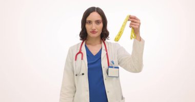 Diyetisyen, beyaz arka planda şerit ve çikolata tutuyor. Doktor çikolatanın kilo üzerindeki olumsuz etkisini açıklıyor. Yavaş çekim