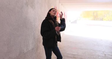 Genç bir kadın alt geçitte tek başına sigara içiyor. Şehir insanı çakmağı tutar ve nefes verir. Erkek arkadaşını beklerken keyifle sigara içer.