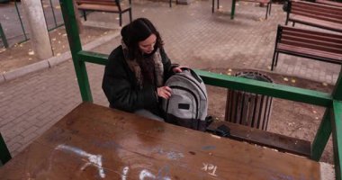 Kadın öğrenci sırt çantasını bankta açar ve şehir parkında defter arar. Genç adam ceplerini karıştırıyor ve sonunda rahatça gülen bir günlük buluyor.